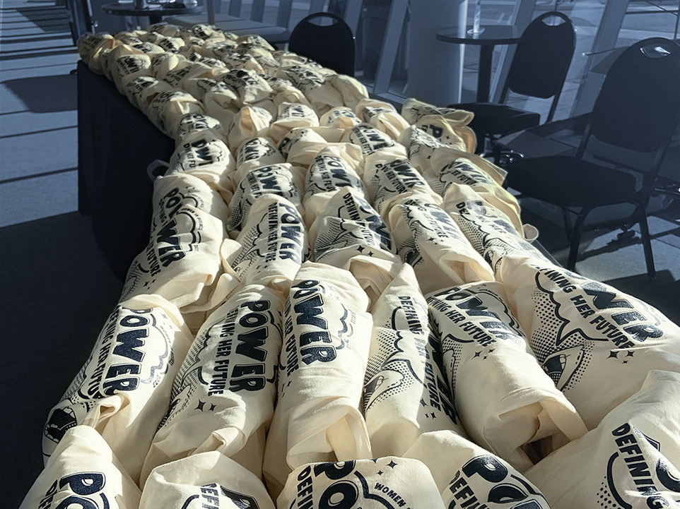 Conference bags spread out on table.